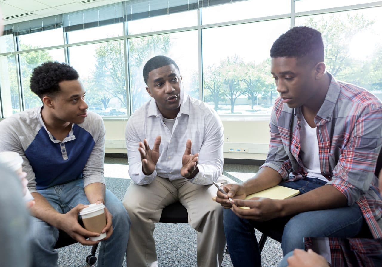 A mentor and participants in a supportive one-on-one conversation