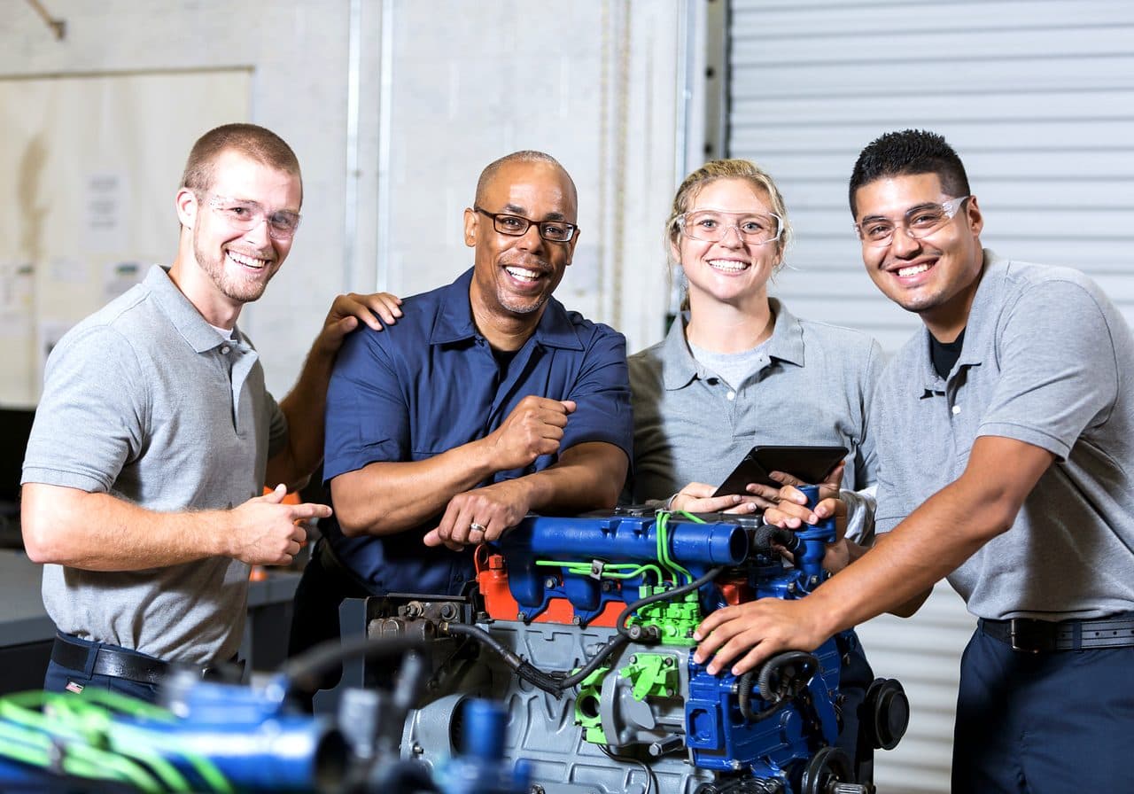 Trainees working together on an engine in a skilled-trades workshop